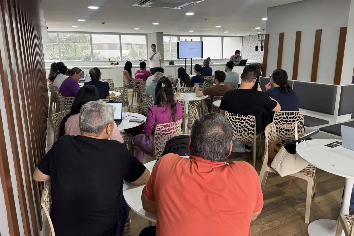 Sala do primeiro encontro da trilha, vista do fundo, com as mesas ocupadas